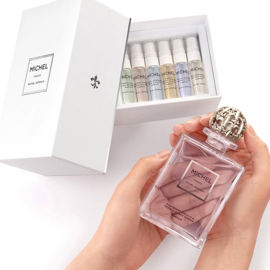 Hand holding Michel Germain Discovery Set featuring French Pear and Queen’s Lilac perfume vials