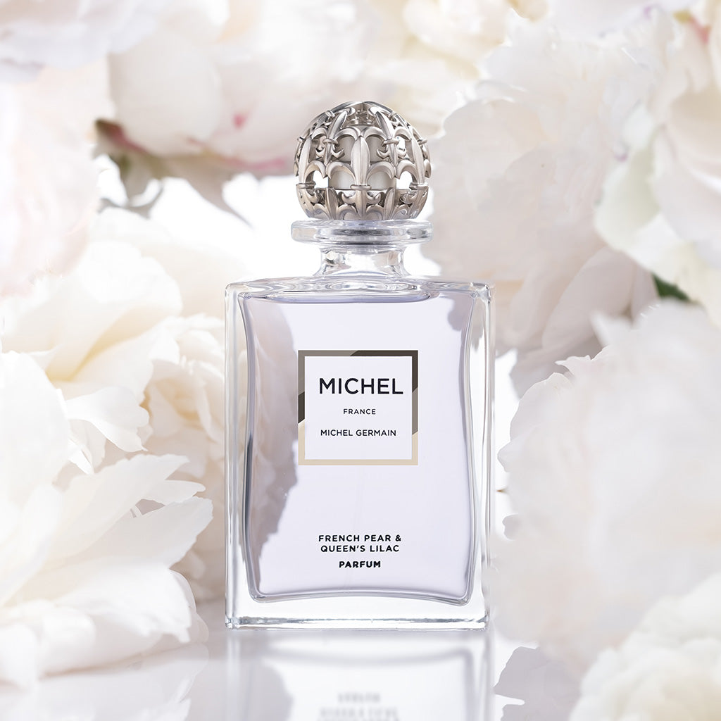 Michel Germain lilac cologne displayed with blooming peonies