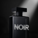 Angled view of Noir Homme cologne with spotlight accent