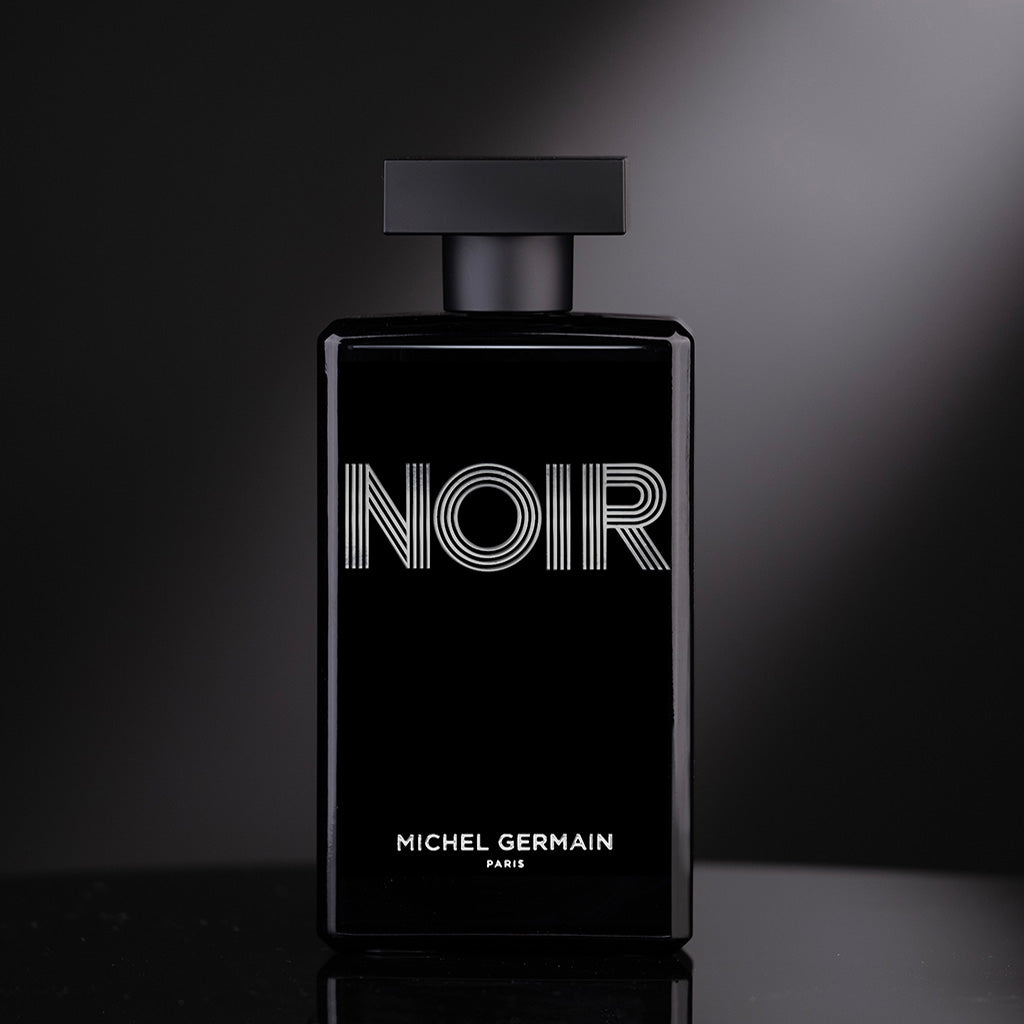 Front view of Noir cologne bottle illuminated dramatically under spotlight