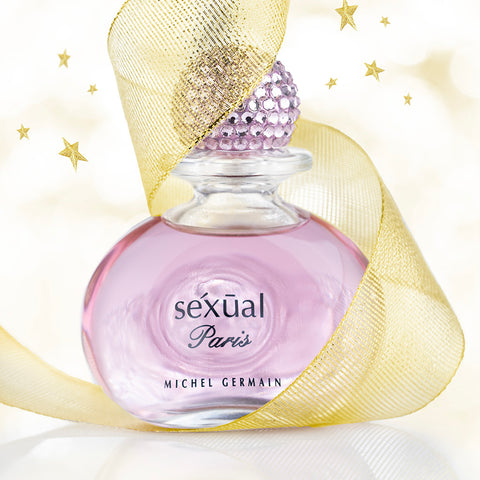 Perfume bottle labeled 'Sexual Paris' by Michel Germain with a gold ribbon on a light background