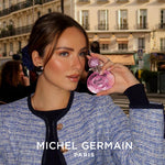 Woman holding Sexual Paris perfume - Michel Germain Paris perfume in elegant Parisian evening setting