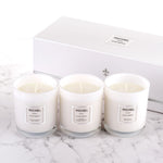Three white candles with the brand name Michel on them, displayed in front of a white box with the Michel logo.
